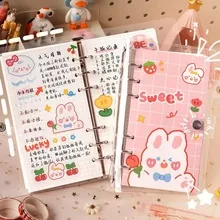 Detailed close-up of a pink plaid A6 binder notebook with 5mm grid pages and cute bunny