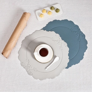 Detail view of vintage embossed faux leather placemats with floral patterns in various colors