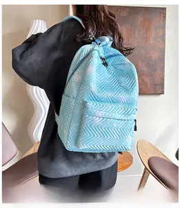Detalle de una mochila acolchada azul claro con patrones de corazones blancos y bolsillo