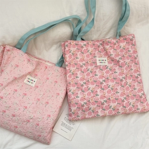 Detailed close-up of quilted floral canvas tote bag with rabbit print and blue handles