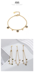Détail du bracelet en perles dorées avec pendentifs ronds en zircon et fermoir homard