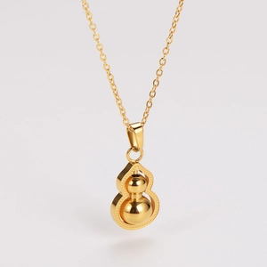 Close-up of golden gourd pendant necklace with polished metal finish on a neutral background