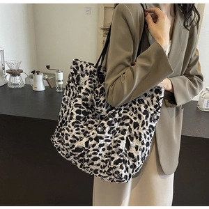Macro detail of high-capacity quilted leopard print tote bag with black shoulder straps