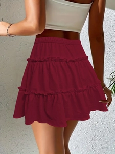 Detail of burgundy tiered mini skirt with elastic high waist and ruffle cake layers