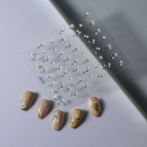 Detail of 3D embossed white daisy nail stickers with FEB-501 design on manicured nails