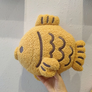Plush yellow Taiyaki fish pillow made of textured sherpa fleece with brown embroidery