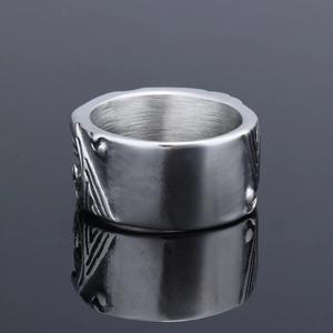 Macro shot of wide silver fish pattern engraving on a polished stainless steel ring