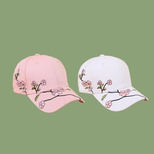 Pink and white baseball caps with cherry blossom embroidery on Morandi green background