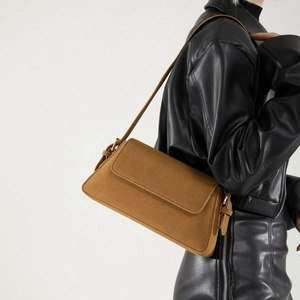 Retro brown faux suede baguette shoulder bag styled with a modern black leather jacket