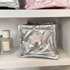 Detail of silver quilted storage bin with pink bow and white lace trim decoration