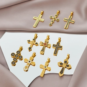 Sortierte goldene Kreuzanhänger aus Edelstahl mit Emaille und Kristallen auf Satin