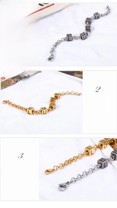 Detail of medical-grade titanium steel bracelet with Lucky cube charms and gold finish