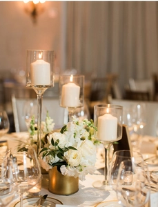 Eleganti portacandele in vetro con candele a pilastro bianche per cene formali