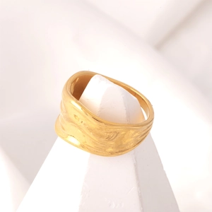 Detailed view of wide gold plated titanium steel ring with organic hammered wave texture