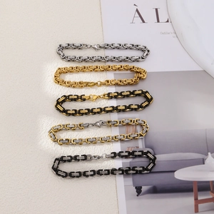 Close-up of five Byzantine style chains in gold, silver, and bicolor finishes on a magazine