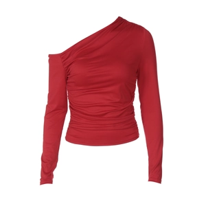 Détail du crop top rouge à une épaule et manches longues avec fronces élégantes