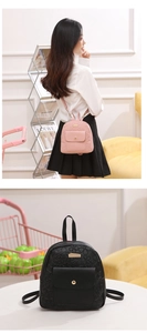 Detail of mini PU leather backpack featuring floral embossed texture in pink and black