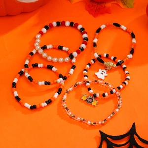 Detalle de pulseras de cuentas de Halloween con dijes de fantasma y murciélago en naranja