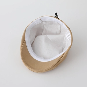 Internal view of khaki cotton flat cap showing white lining and 100% cotton label