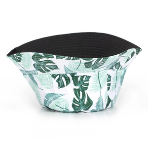 Détail d'un chapeau bob réversible avec imprimé de feuilles tropicales et côté noir uni
