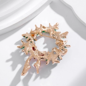 Back view of gold Christmas wreath brooch with detailed pin fastener and leaf texture