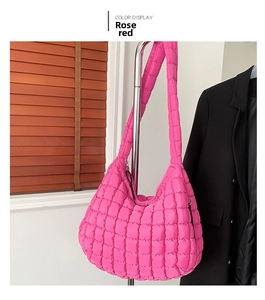 Close-up of rose red quilted puffer shoulder bag with square stitching and zip closure