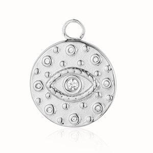 Macro shot of silver evil eye pendant with embossed details and clear gemstones