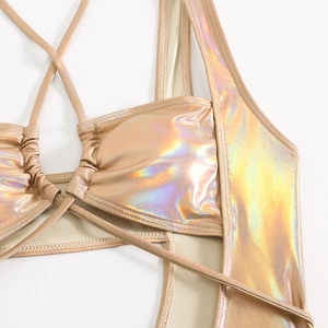 Detail of laser gold monokini featuring drawstring ruching and metallic finish texture