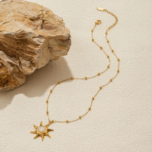 Detailed close-up of 18K gold stainless steel sun pendant with opal on beaded chain