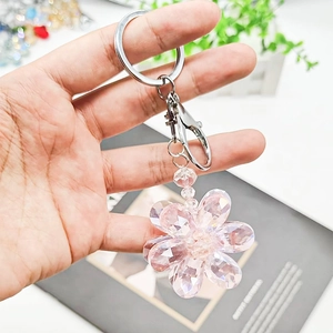 Close-up of pink crystal flower keychain held in hand, showing sweet and elegant details
