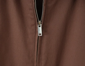 Macro view of silver metal zipper and brown twill cotton fabric on a vintage jacket