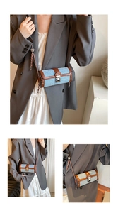 Detail view of denim and leather cylindrical crossbody bag with metal chain strap