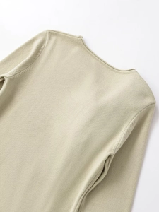Dettaglio della trama in maglia fine e cucitura della spalla su maglione verde chiaro