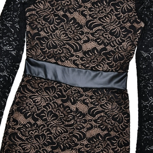 Close-up of black lace bodysuit featuring nude lining and a glossy satin waist belt