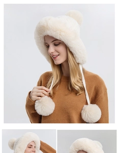 Close-up of white plush earflap hat with soft faux fur texture and large pom-pom details