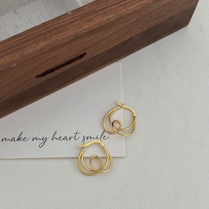 Minimalist 925 sterling silver knotted earrings with golden finish on wooden box