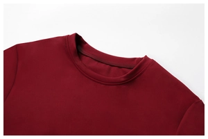 Close-up of a burgundy yoga top featuring a reinforced ribbed crew neck and fine stitching