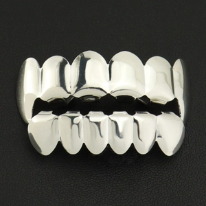 Detailed macro view of silver hip hop teeth grillz set on black leather background