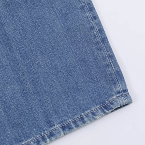 Nahaufnahme der Textur von blauer Jeans und hochwertiger Naht am Saum der Hose