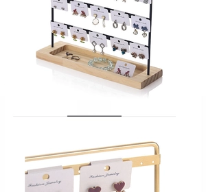 Detail of metal earring organizer with wood base grooves for rings and bracelets