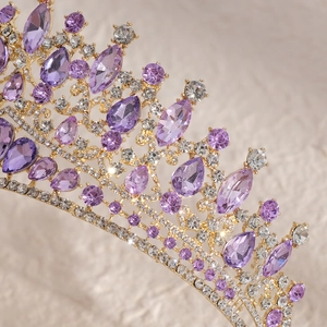 Macro detail of luxury gold bridal crown featuring purple rhinestones and crystal accents
