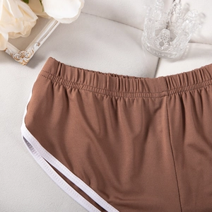 Detail braune Yoga-Shorts mit weißer Paspelierung und elastischem hohem Bund