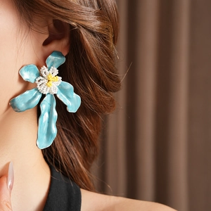 Gros plan de boucles d'oreilles fleurs bleues avec pistils en perles blanches pour l'été