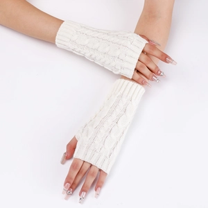 Detail view of white cable knit fingerless gloves showing thick textured arm warmer patterns
