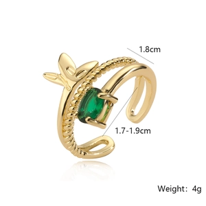 Detail view of gold ring with green gemstone featuring leaf and rope textures