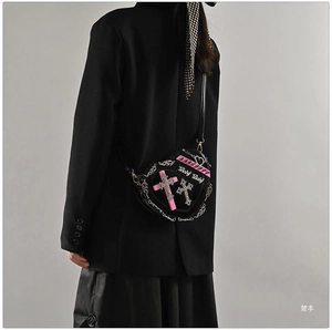 Detail view of heart-shaped Y2K punk shoulder bag with rivets and cross decor