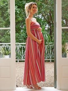 Macro detail of high-waist striped maternity maxi dress on a floral balcony setting
