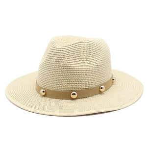 Detail of beige Panama hat featuring brown suede band and five golden metallic studs