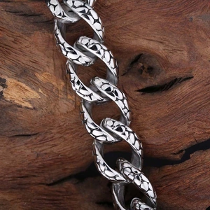 Men's stainless steel Cuban link bracelet featuring detailed snake skin texture pattern