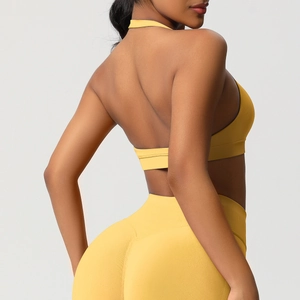 Détail du soutien-gorge de sport licou jaune et du legging taille haute montrant le dos nu